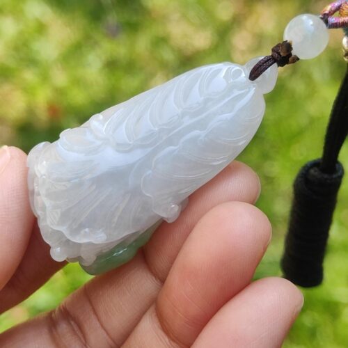 Una mano sosteniendo un colgante de jade.