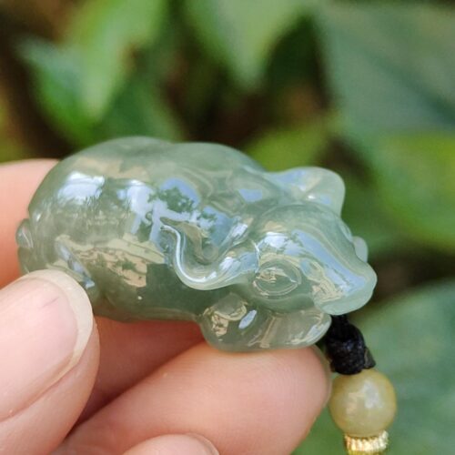a hand holding a jade frog