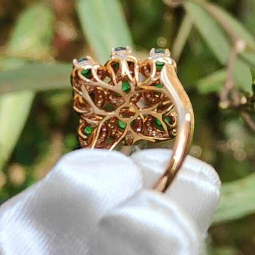 a gold ring with green stones