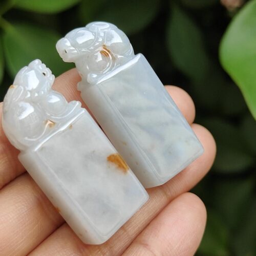 a hand holding a pair of carved white stones