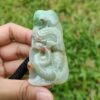 a hand holding a jade sculpture