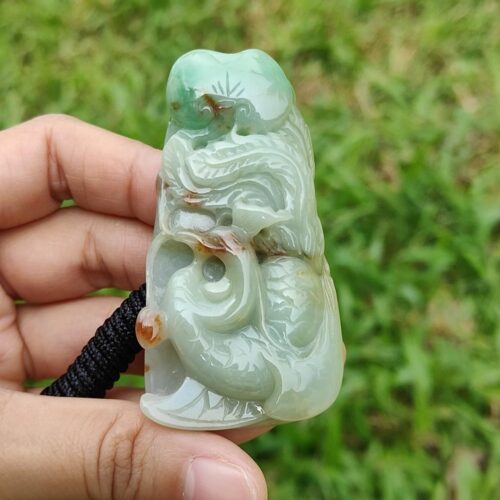 a hand holding a jade sculpture