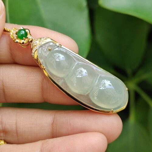 a hand holding a jade pendant