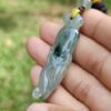 a hand holding a jade necklace