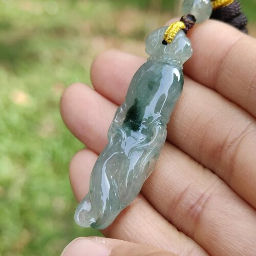 a hand holding a jade necklace