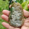 a hand holding a stone pendant