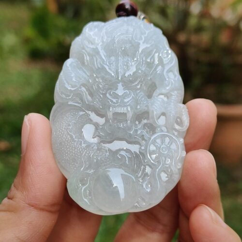 Una mano sosteniendo un colgante de jade.