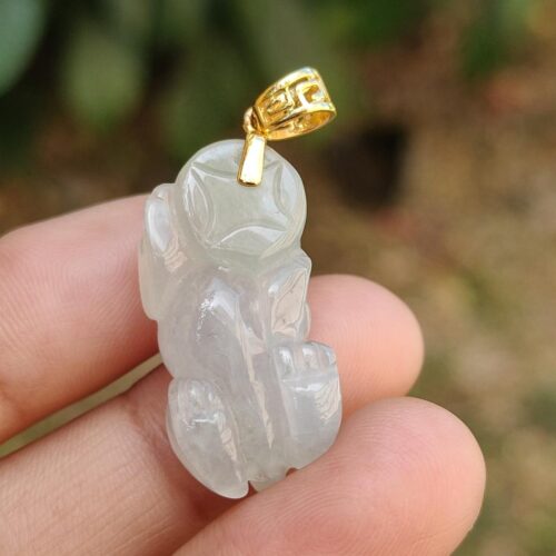 Una mano sosteniendo un colgante de jade.