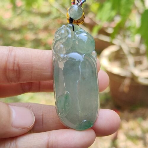 Una mano sosteniendo un colgante de jade.