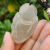 Una mano sosteniendo un colgante de jade.