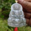 a hand holding a jade pendant