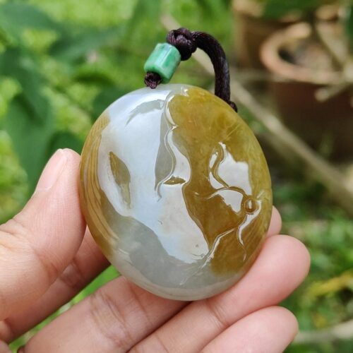 a hand holding a stone pendant