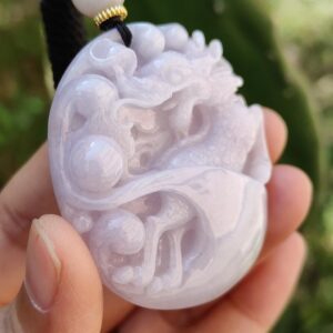 Una mano sosteniendo un colgante de jade.