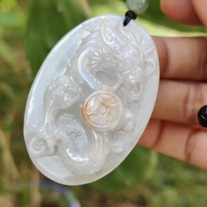 एक हाथ में जेड पेंडेंट थामे हुए