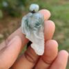 Una mano sosteniendo un colgante de jade.