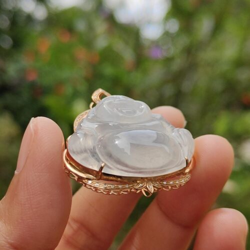 a hand holding a white jade pendant