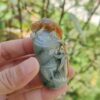 Una mano sosteniendo un pequeño objeto de piedra.