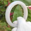a hand in glove holding a white ring