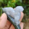 a hand holding a small stone animal