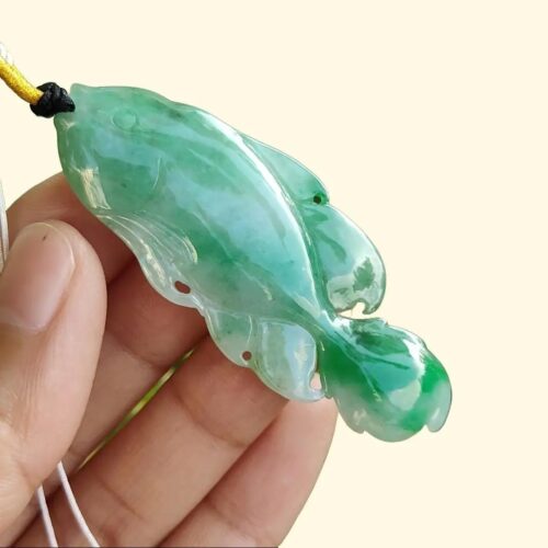 một bàn tay cầm một mặt dây chuyền ngọc bích