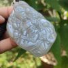 Una mano sosteniendo un colgante de jade.
