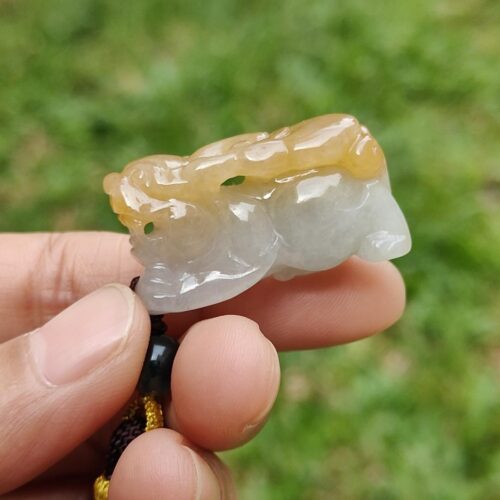a hand holding a small white and yellow stone