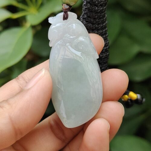 ஜேட் பதக்கத்தை வைத்திருக்கும் ஒரு கை