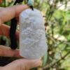 Una mano sosteniendo un colgante de jade.