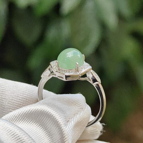 a ring with a green stone in a hand