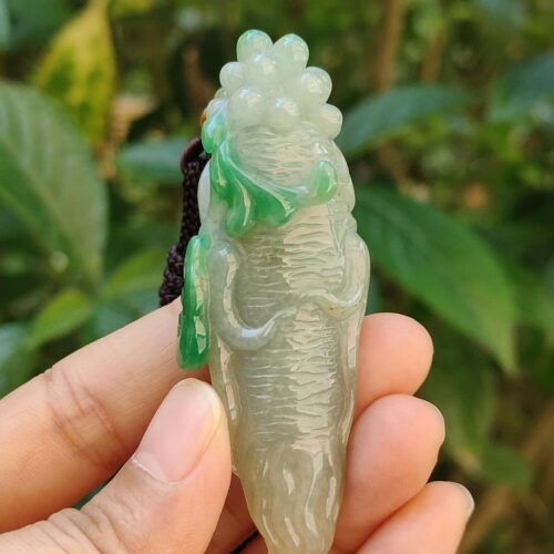 Una mano sosteniendo un colgante de jade.