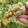 Una mano sosteniendo un colgante de jade.