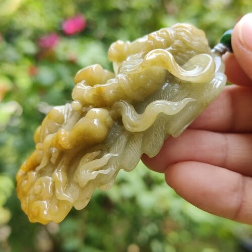 Una mano sosteniendo un colgante de jade.