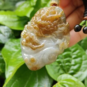 Una mano sosteniendo un colgante de jade.