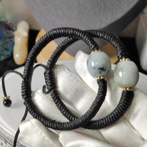 a black and white bracelet with a blue and white bead