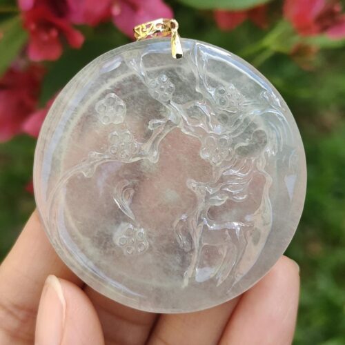 a hand holding a round white pendant