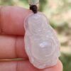 a hand holding a jade pendant