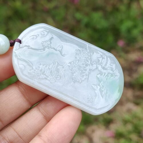 Una mano sosteniendo un colgante de jade.