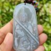 Una mano sosteniendo un colgante de jade.