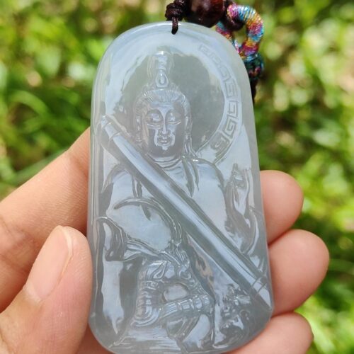 Una mano sosteniendo un colgante de jade.