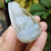 a hand holding a jade pendant