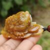 a hand holding a small frog shaped stone