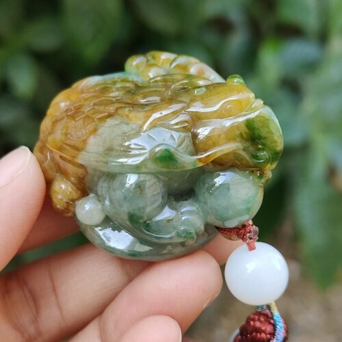 Una mano sosteniendo un colgante de jade.