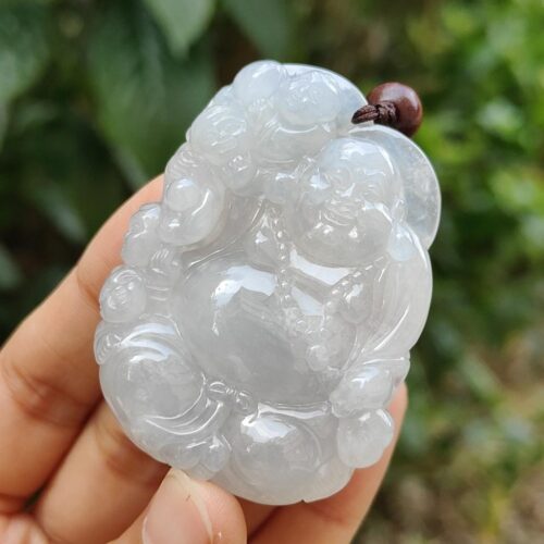 a hand holding a jade buddha