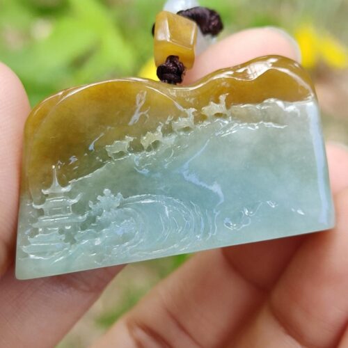 Una mano sosteniendo un colgante de jade.