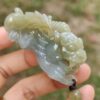 a hand holding a jade dragon