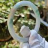 a hand in glove holding a circular object