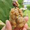 Una mano sosteniendo un colgante de jade.