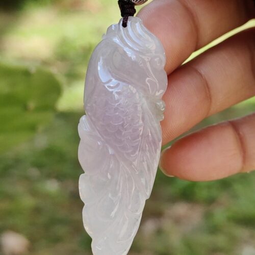 Una mano sosteniendo un colgante de jade.