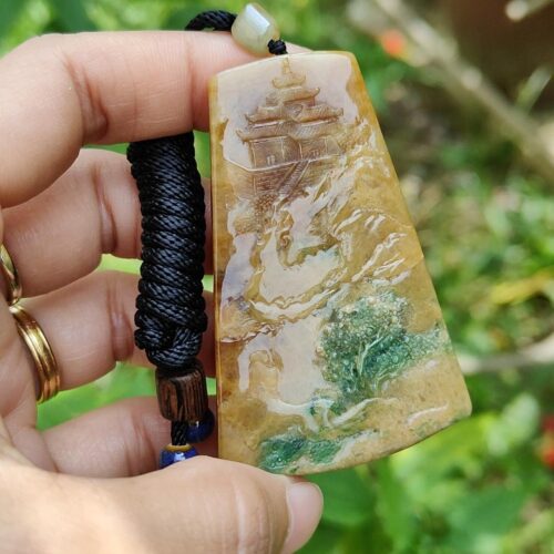 Una mano sosteniendo un colgante de piedra.