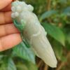 Una mano sosteniendo un colgante de jade.